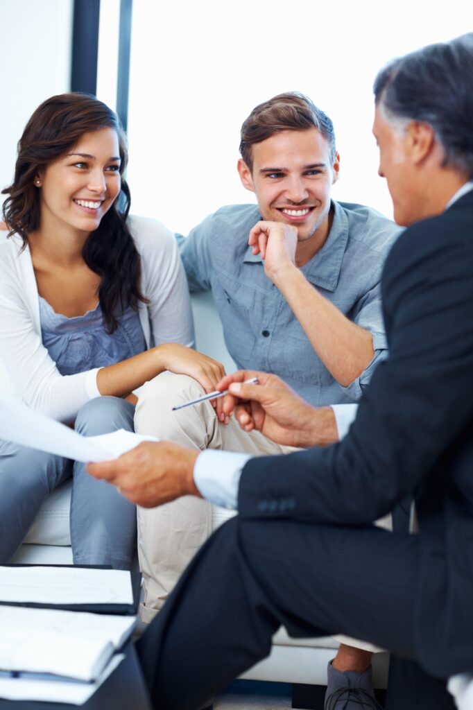 Mature advisor explaining financial plan to couple at home