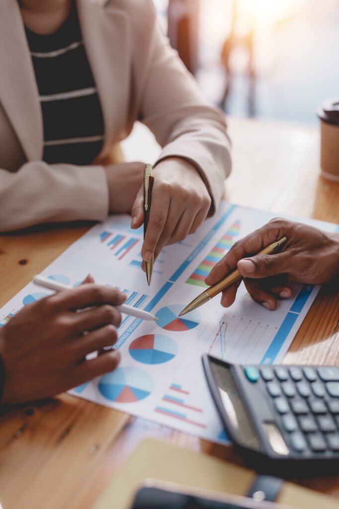Business people meeting pointing graph and chart to analyze financial and marketing investment.